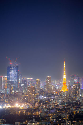 Illuminated buildings against sky at night