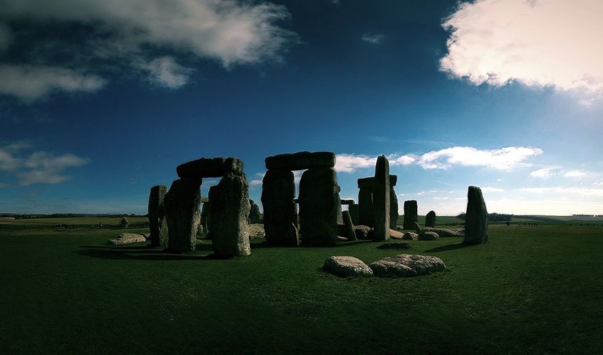 Stonehenge on grassy landscape against sky