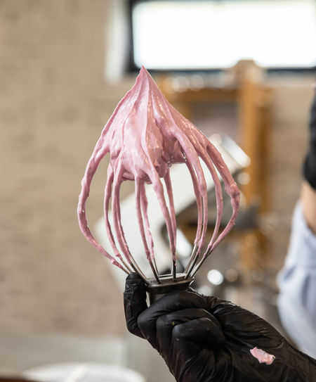 Pink marshmallow mass or whipped meringue with stable peak on mixer whisk 