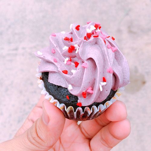 Cropped image of hand holding cupcake