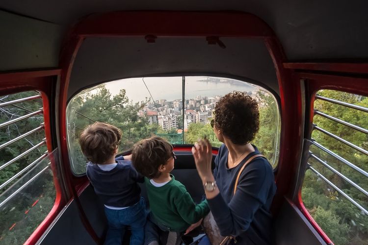 Mother sitting with children in overhead cable car