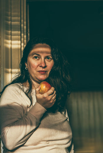 Portrait of woman holding apple
