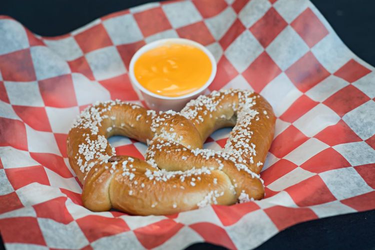 Close-up of pretzel with cheese in paper