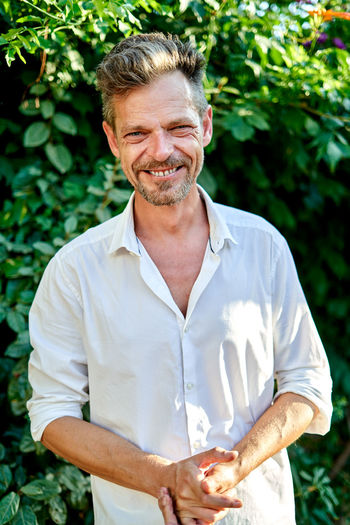 Portrait of senior man holding plant