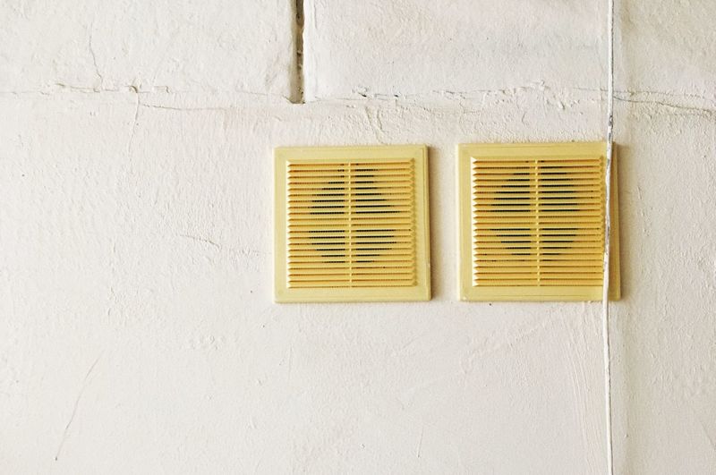2 yellow ventilation grills on the wall