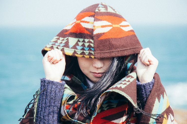 Close-up of a young woman in hood jacket