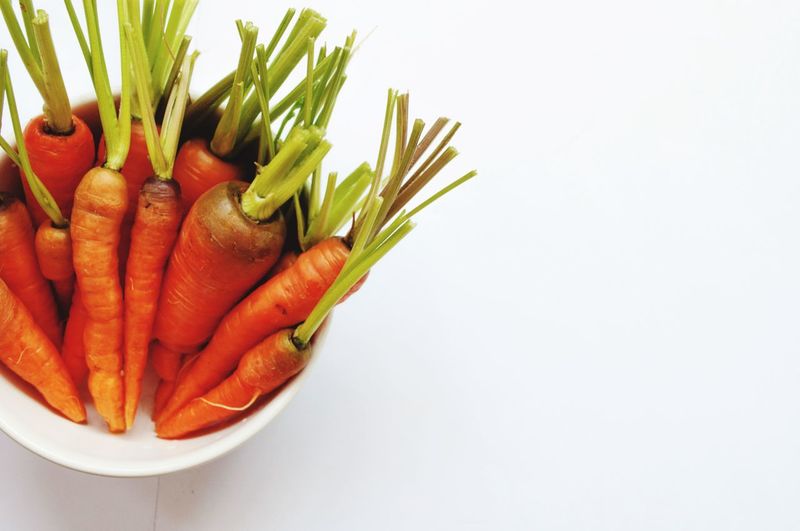 Close-up of vegetables in plate against white background