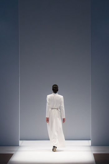 Rear view of fashion model walking on ramp