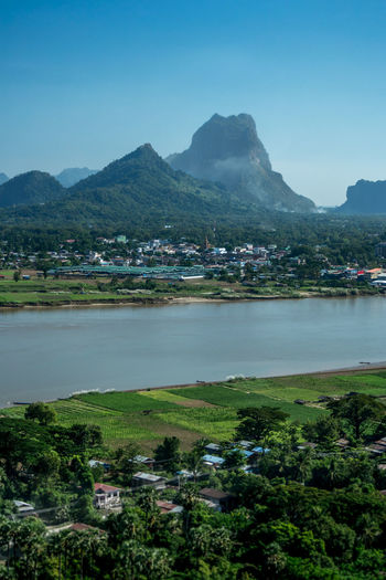 Scenic view of river and mountains against blue sky