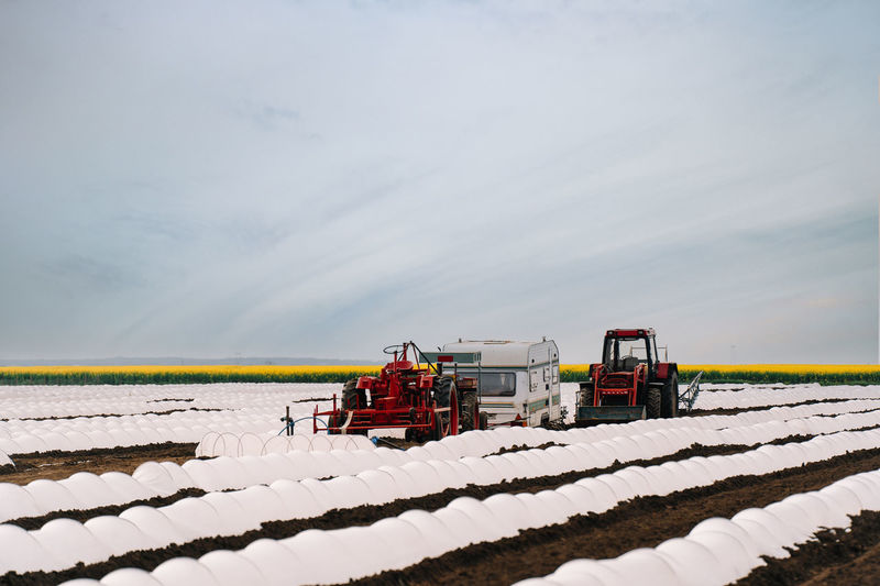 Agricultural machines on field against sky