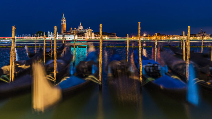 View of boats moored in canal at night