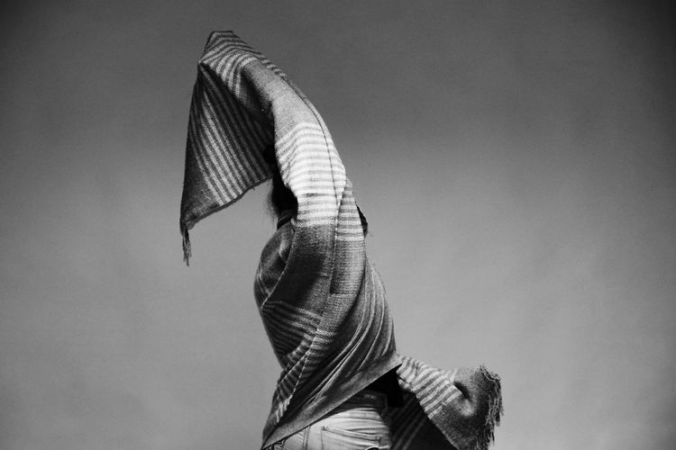 Close-up of woman with scarf dancing against sky