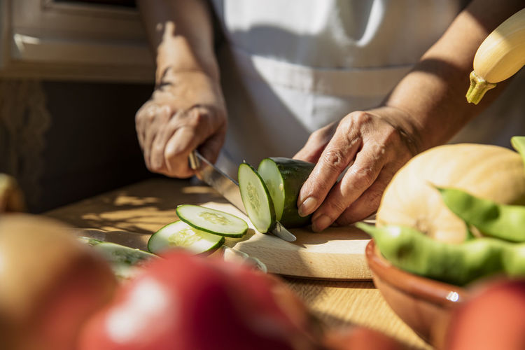 Cropped image of person preparing food on cutting board