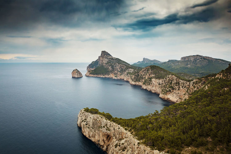 Scenic view of sea and mountains against sky