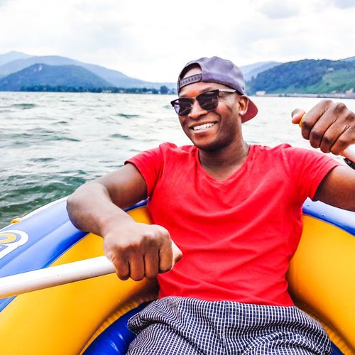Portrait of young man swimming in boat in sea
