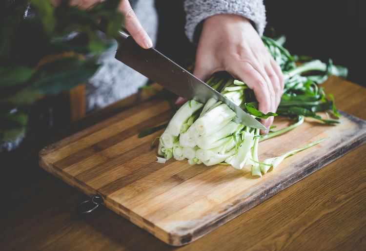 Cropped image of hands cutting vegetables