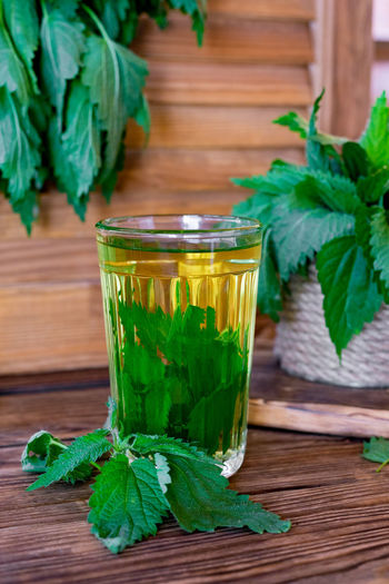 Healing herbal tea with nettle. tea in a glass on a wooden table. he source of vitamins