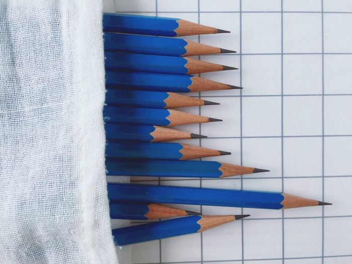 High angle view of blue pencils on paper