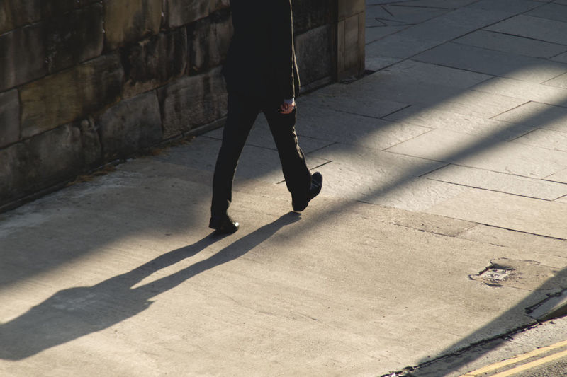 Low section of person walking on street