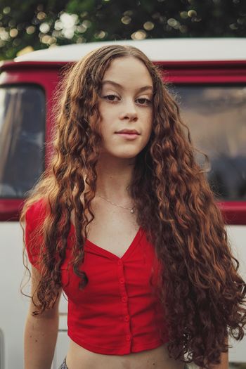 Portrait of teenager girl standing by van