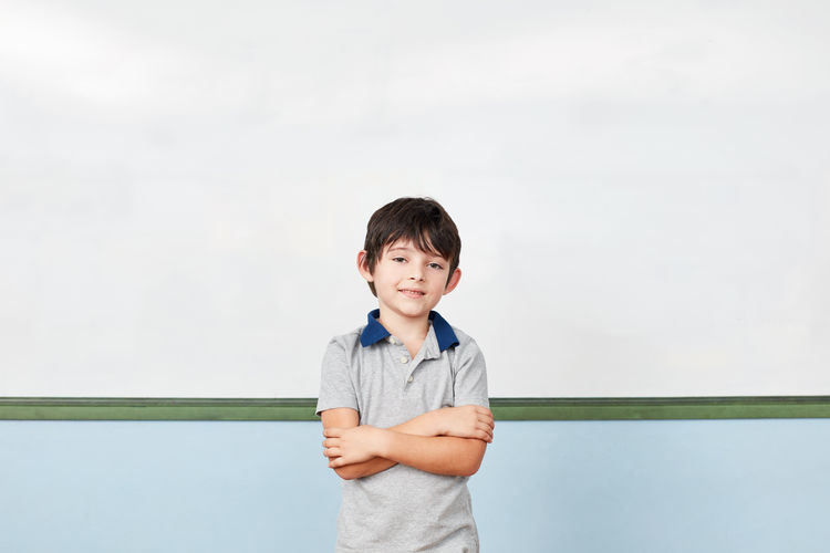 Portrait of cute boy standing against clear sky