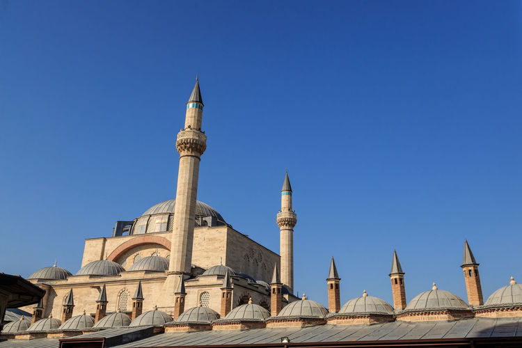 Low angle view of mosque against clear blue sky