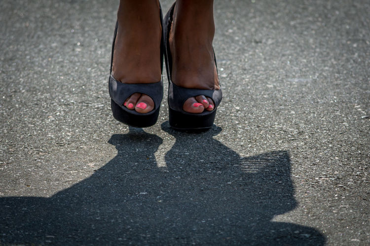Low section of woman wearing black leather shoes