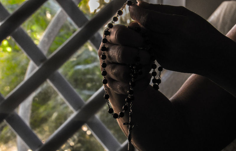 Close-up of hand holding rosary