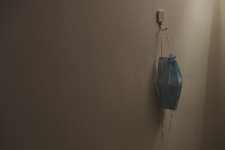 Close-up of electric lamp hanging against wall