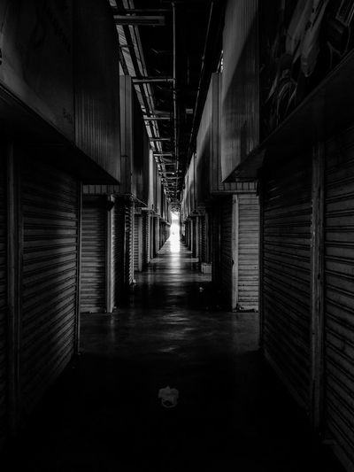 Empty corridor amidst stores in building
