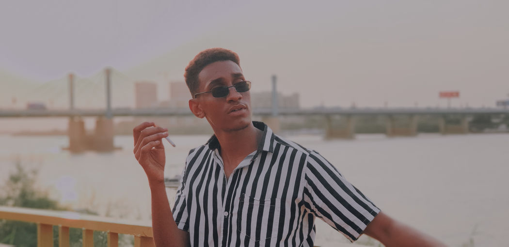 Portrait of young man standing against built structure