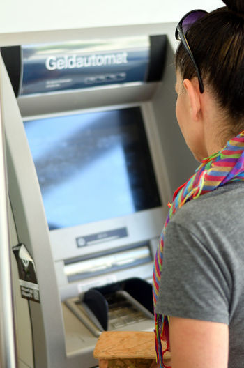 Side view of mature woman using atm