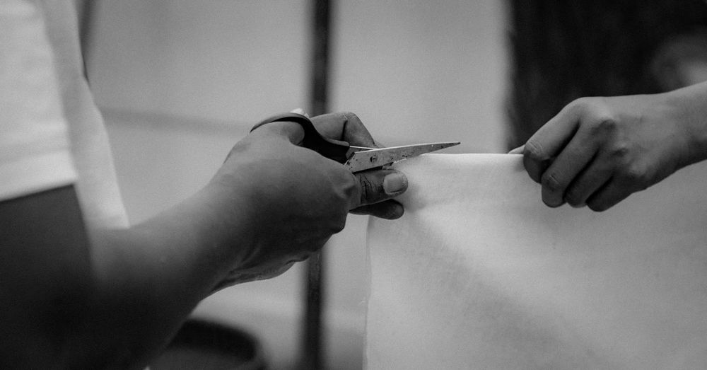 Close-up of people cutting textile at home