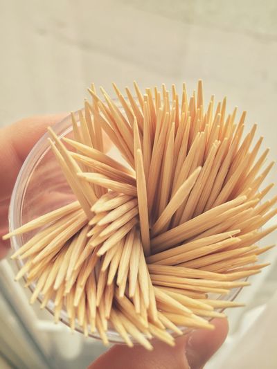 Cropped image of hand holding container with toothpicks