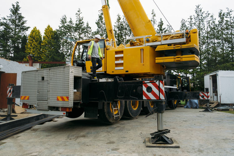 Operator on construction crane lifting heavy freight. modern mobile transportation technologies help