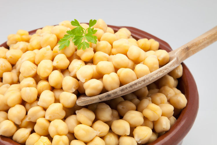 Close-up of chickpeas in bowl against white background