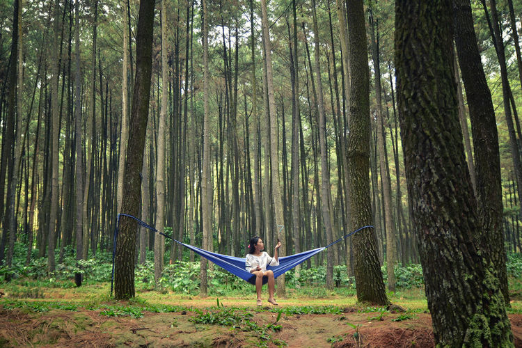 Full length of woman sitting in a hammock