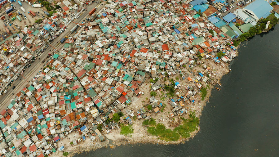 Slums with shacks of local residents and the river bank littered with garbage. manila, philippines.