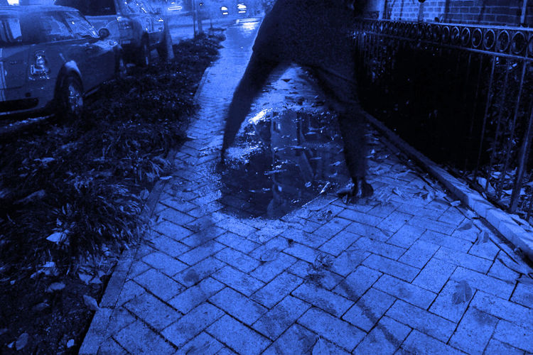 Woman walking on cobblestone at night
