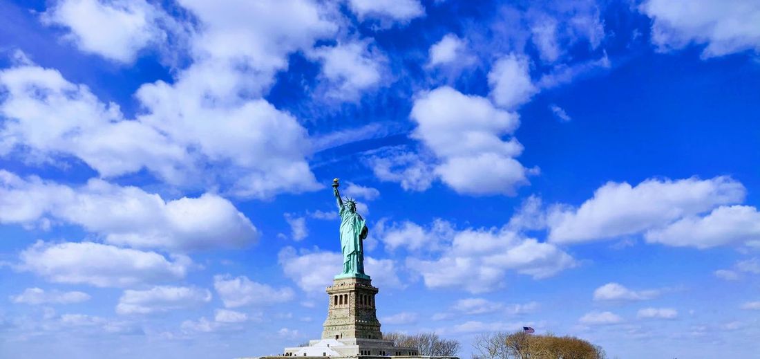 Statue of liberty on a cold winter day with blue sky and scattered clouds