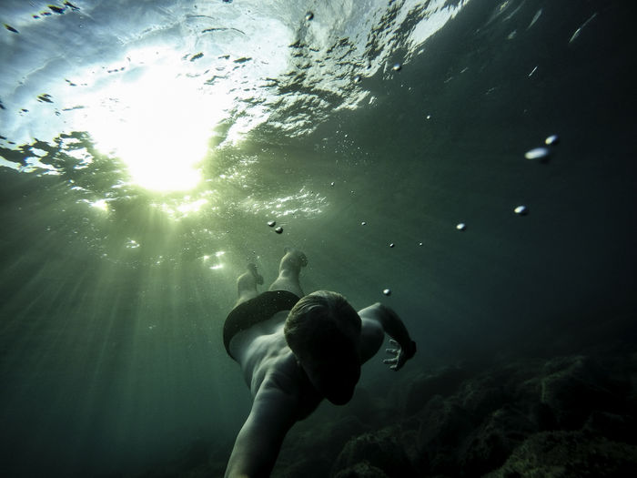 Low angle view of man swimming in sea