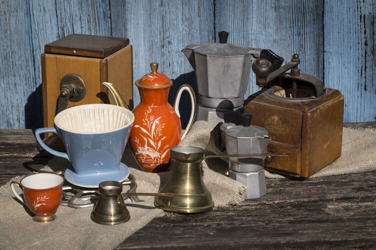 Close-up of old objects on table against wall