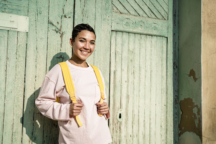 Smiling woman with short hair in front of old door