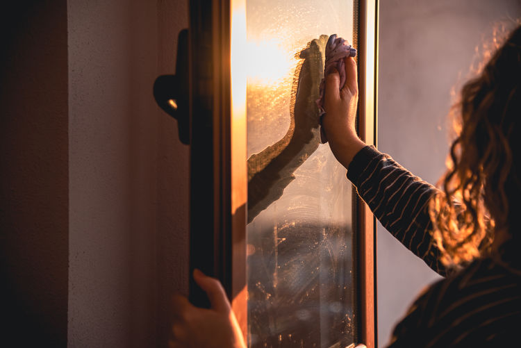 Portrait of woman photographing through window