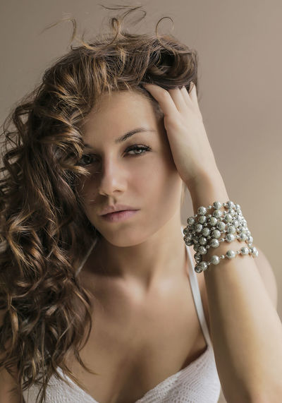 Portrait of beautiful young woman wearing bracelet over colored background