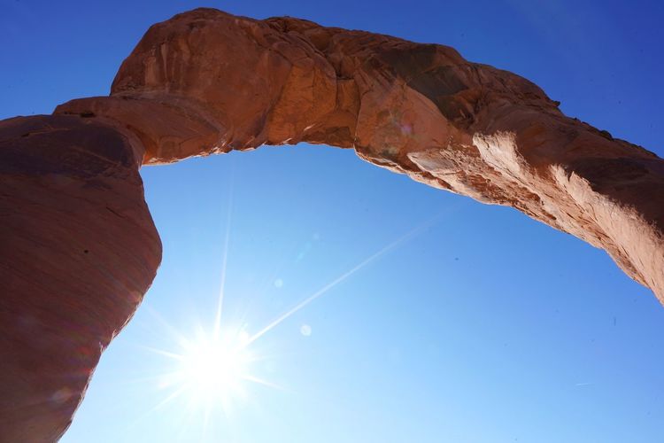 Low angle view of natural arch against clear blue sky