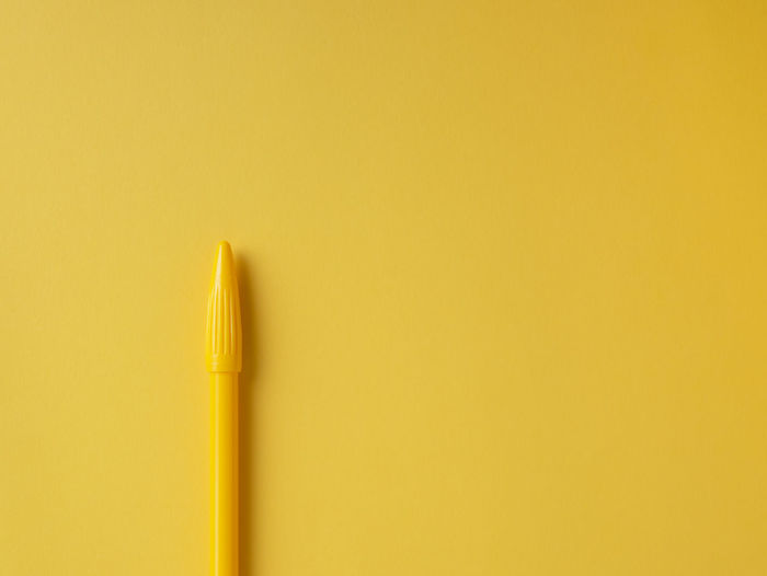 Close-up of pencils against yellow background