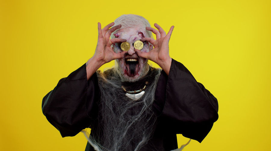 Portrait of man wearing mask against yellow background