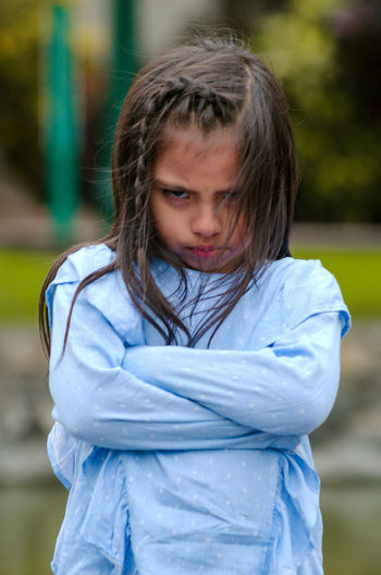 Portrait of cute angry girl standing in park