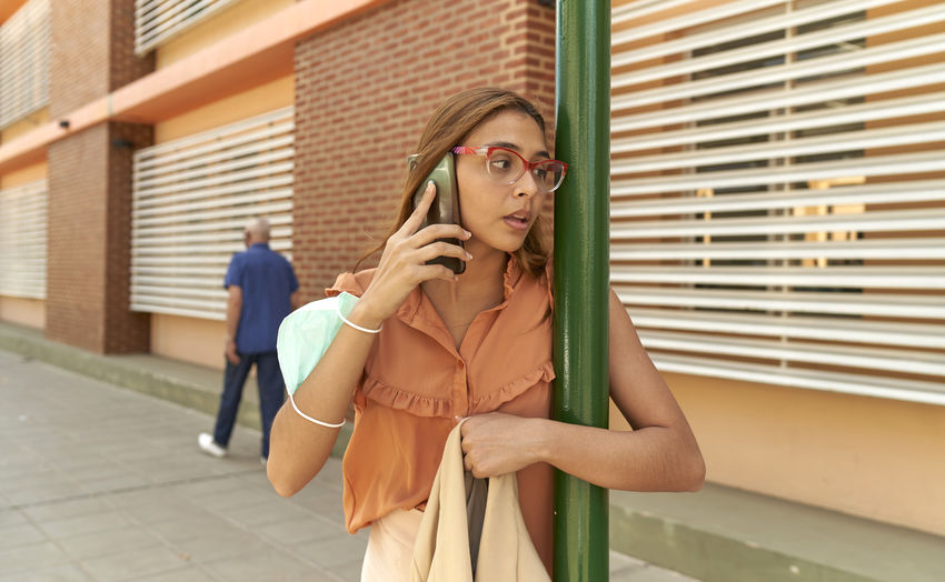Young female businesswoman talking with her cell phone outdoors